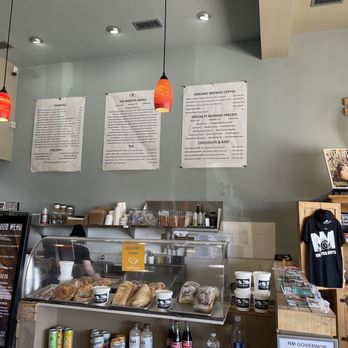 Cafe Bella Coffee - Yum - Inside Cafe Bella Coffee, with menu boards on the wall, pendant lighting, and a counter with food and drink items. - Coffee & Tea Near Me - Rio Rancho, New Mexico