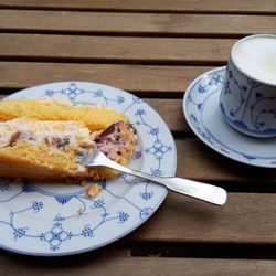 Café im Kräutergarten - Ein Stück Baiser-Pflaumen-Torte mit einem Cappuccino