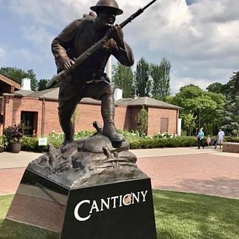 Cantigny - A bronze statue of a soldier with a helmet and uniform, holding a spear, is situated outdoors at Cantigny Park, with trees and visitors in the background. - Museums Near Me - Wheaton, Illinois