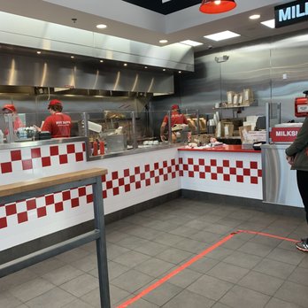 Five Guys - a man standing in front of a counter in a fast food restaurant - Burgers Near Me - Coralville, Iowa Five Guys - a man standing in front of a counter in a fast food restaurant - Burgers Near Me - Coralville, Iowa