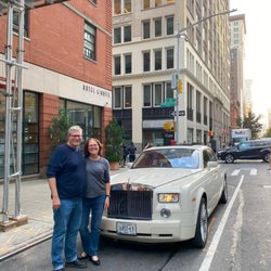 Happy couple in front of a beautiful Camelot car.