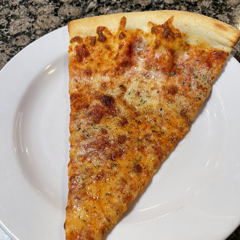 Mezza Luna Pizzeria - a slice of pizza on a plate - Pizza Near Me - Eugene, Oregon