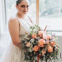 Brush Valley Floral - Bridal Bouquet: Bride carrying a romantic hand-tied wedding bouquet featuring peach roses, orange blooms and lush greenery.