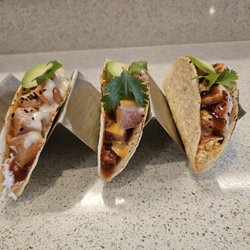Sushi Tomo - Three fresh Sushi Tacos with tuna, salmon, and albacore, topped with avocado, cilantro, and signature sauces.