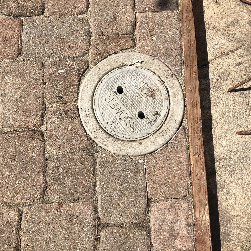 a manhole on a brick sidewalk a manhole on a brick sidewalk