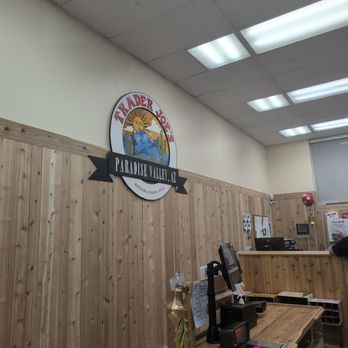 Trader Joe's - Cute location sign - Inside Trader Joe's in Paradise Valley, AZ, the image shows the store's sign on a wooden-paneled wall and the checkout counter with cash registers and equipment. - Grocery Near Me - Phoenix, Arizona