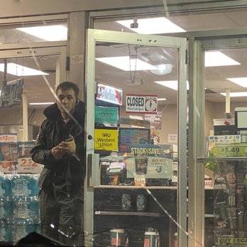 Allsups - a man looking at his cell phone in a store - Convenience Stores Near Me - Albuquerque, New Mexico