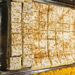 Coconut cream square dessert with toasted coconut flakes on top. Silky creamy filling paired with crisp crust, rich milky coconut aroma, mil