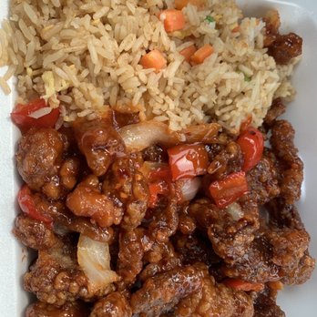 Panda Express - Beijing Beef - A foam takeout container contains fried rice with vegetables and sweet and sour chicken with sauce. - Chinese Near Me - Hamilton, New Jersey