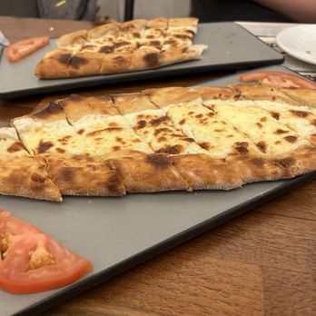 Istanbul Grill - Egg pide in the front, cheese pide in the back.   48. Yumurtal Pide -Egg Pide 45. Peynirli Pide -Cheese Pide - Turkish Near Me - Houston, Texas
