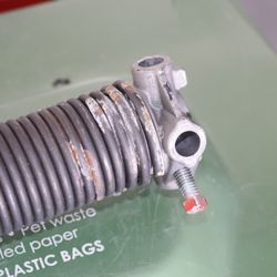 The Garage Door Company - One of four shorter (used?) springs used to replace original springs.  Appe to be used springs.
