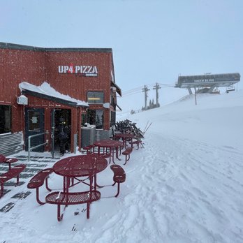 Up 4 Pizza - red tables and benches in the snow - Pizza Near Me