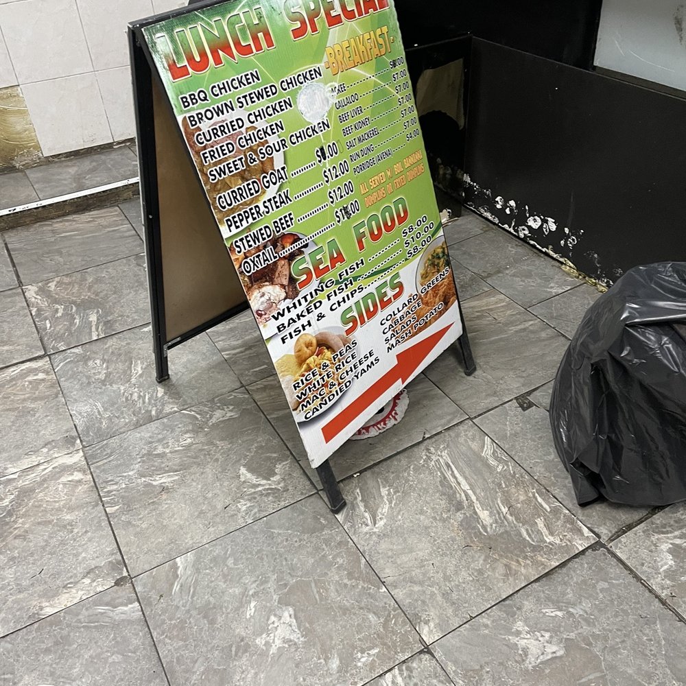 Easy Corner - a person sitting on a chair next to a sign - Caribbean Near Me - New York, New York