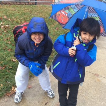 River Oaks Elementary School - Two kids outside the school in the rain - Elementary Schools Near Me - Woodbridge, Virginia