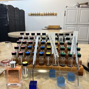 Aroma Workshop - Various oils to smell and choose from. The square blocks with white paper tags are the three samples they created from the oils we selected. - Perfume Near Me - Chicago, Illinois