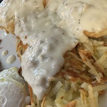 Biscuits Cafe - (1) Biscuit and Gravy - A breakfast plate featuring biscuits with gravy, hash browns, and a fried egg, served on a white plate. - Breakfast & Brunch Near Me - Glendale, Arizona