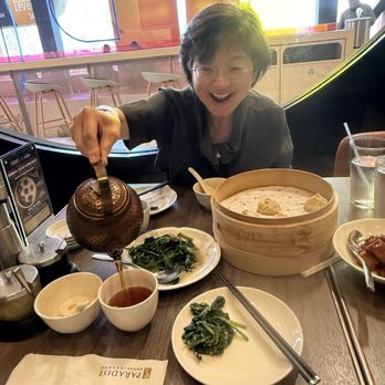 Paradise Dynasty - My sister pouring her favorite Jasmine Tea:  she really loves the Garlic Spinach - Singaporean Near Me - Costa Mesa, California