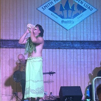 Smith's Family Garden Luau - Using a conch shell to signify an important start to an event - Music Venues Near Me - Kapaa, Hawaii