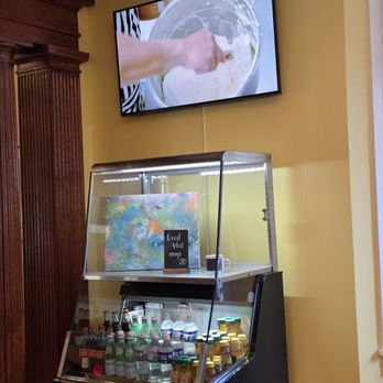 Albemarle Coffee House - Different bottled drinks as well as a display case of a local artwork and Mugs of this artwork available for sale. - Coffee & Tea Near Me - Roanoke, Virginia