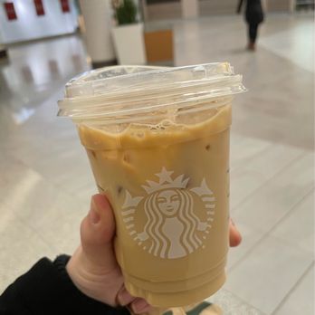 Starbucks - a hand holding a cup of iced coffee - Coffee & Tea Near Me - Saint-Laurent, Quebec