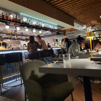 Blossom & Bourbon - The bar at the center has seating at the bar and surrounding tables - American Near Me - San Jose, California Blossom & Bourbon - The bar at the center has seating at the bar and surrounding tables - American Near Me - San Jose, California