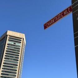 The Charm'tastic Mile Street Sign with the World Trade Center Building in the background.