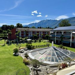 Hotel Hapimag Villa Saleggi Resort & Spa - Blick in den Garten, mit Dach des Schwimmbads