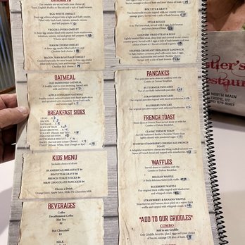 Rustler's Restaurant - The menu is divided into sections including omelets, oatmeal, breakfast sides, kids menu, beverages, and traditional favorites. It lists specific dishes such as veggie lovers omelet, egg white omelet, and stuffed croissant breakfast sandwich, along with prices. The traditional favorites include American breakfast, biscuits & gravy, steak & eggs, and stuffed croissant sandwich. The menu also offers pancakes, French toast, waffles, and add-on options for grilled items. Beverages include coffee, hot tea, hot chocolate, milk, and juice. - American Near Me - Tropic, Utah