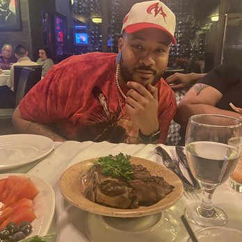 American Prime - a man sitting at a table with food - Steakhouses Near Me - Rye Brook, New York