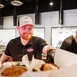 The Original Roy Hutchins Barbeque - Zack Hutchins serving up a platter of all our Roy Hutchins BBQ favorites.