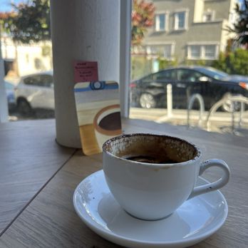 The Coffee Movement - A mocha with the free book mark and the view of the street out front - Coffee & Tea Near Me - San Francisco, California