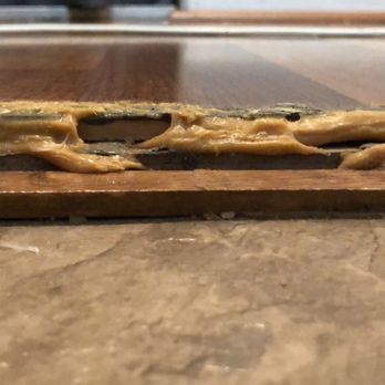 Empire Today - You can again see where the floor is lifting up. The laminate was not laid on concrete floor. See vinyl in kitchen and how it lays flat - Carpet Installation Near Me