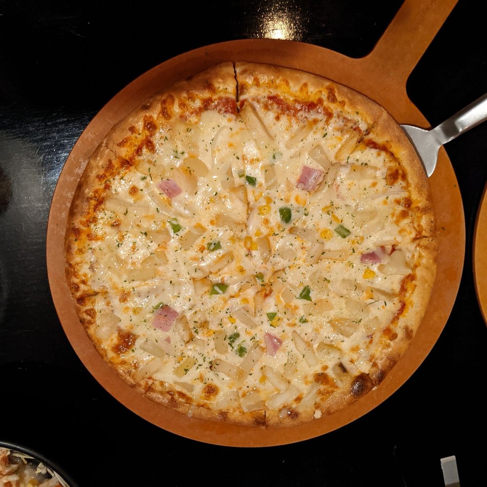 Potato pizza with cheese, potato, onion, green pepper, corn, ham,.pineapple