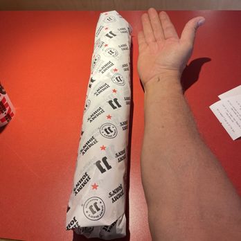 Jimmy John's - a person's hand holding a wrapper - Sandwiches Near Me - Guilderland, New York