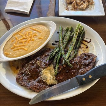 Twisted Restaurant & Bar - Ribeye, cheesy grits & sautéed asparagus - Steakhouses Near Me - Myrtle Beach, South Carolina Twisted Restaurant & Bar - Ribeye, cheesy grits & sautéed asparagus - Steakhouses Near Me - Myrtle Beach, South Carolina