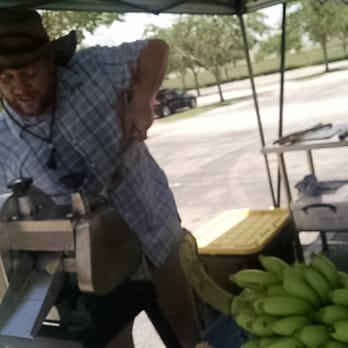 Farmer Fred - Fred pressing cane juice while his boy munches on longan - Farmers Market Near Me - Miami, Florida Farmer Fred - Fred pressing cane juice while his boy munches on longan - Farmers Market Near Me - Miami, Florida