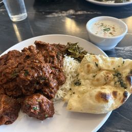 Goat vindaloo with garlic naan and raita