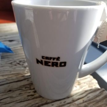 Caffè Nero - a white coffee cup on a wooden table - Coffee & Tea Near Me - Boston, Massachusetts