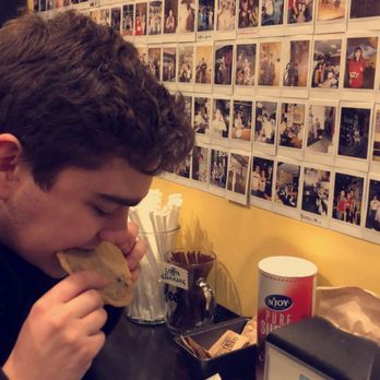 Bakeshop - Enjoying a half snickerdoodle half chocolate chip cookie in front of their photo wall! - Desserts Near Me - Arlington, Virginia
