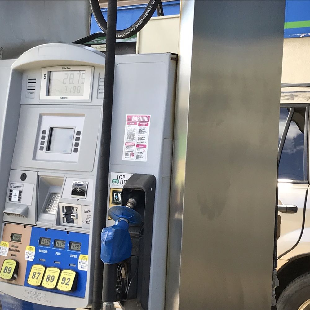 a gas pump and a car at a gas station a gas pump and a car at a gas station