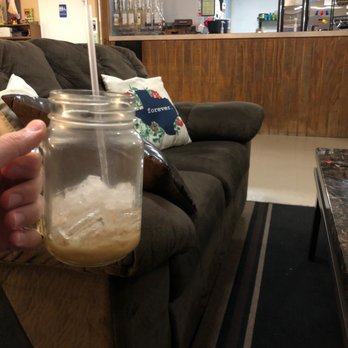 Angelita's Casa de Cafe - a hand holding a mason jar filled with iced coffee - Coffee & Tea Near Me - Brownsville, Texas
