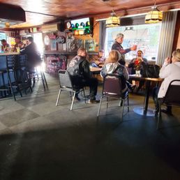 a group of people sitting around a pool table
