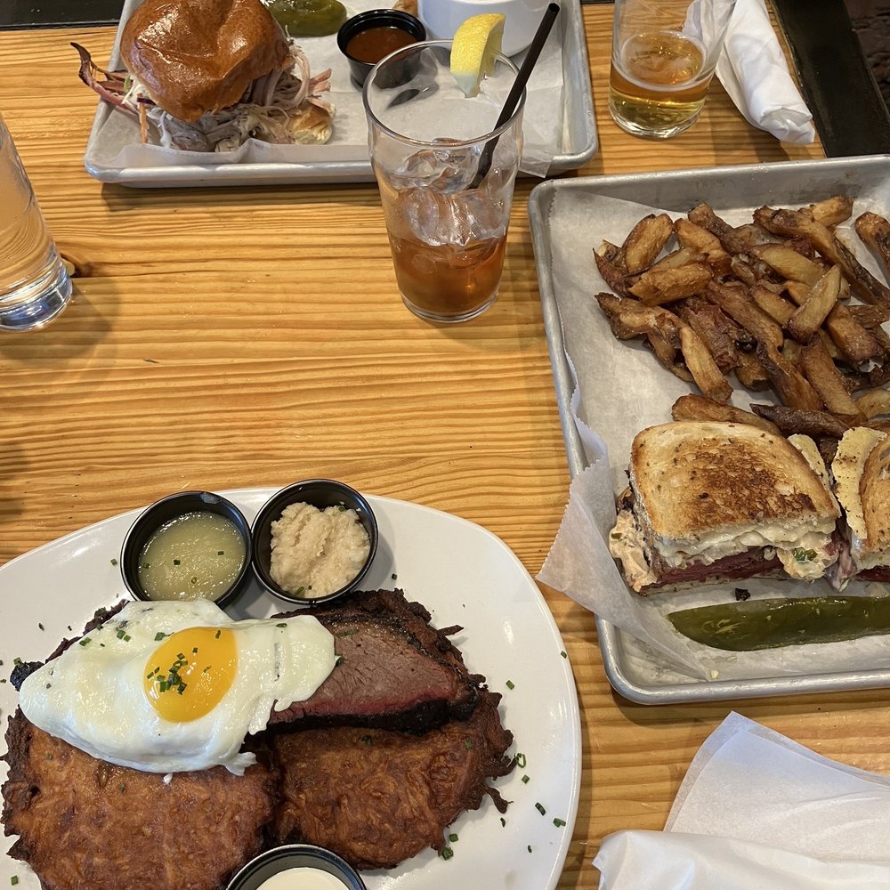 Potato pancakes with brisket (bottom). Pulled pork sandwich with broccoli slaw (top) and Ruben with fries. Potato pancakes with brisket (bottom). Pulled pork sandwich with broccoli slaw (top) and Ruben with fries.