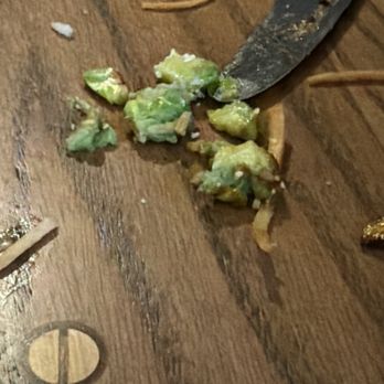 Tavern in the Square - No avocado was ordered. - A knife is slicing through a green avocado on a wooden table, with avocado pieces scattered around. - Sports Bars Near Me - Salem, New Hampshire