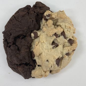 Crumbl - Pewaukee - A large cookie is divided into two halves: one side is chocolate with a dark color, and the other is vanilla with chocolate chips. - Bakeries Near Me - Pewaukee, Wisconsin
