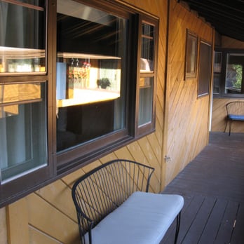 Murphy's River Lodge - A bench just outside the front entry door to a guest room. - Hotels Near Me - Estes Park, Colorado