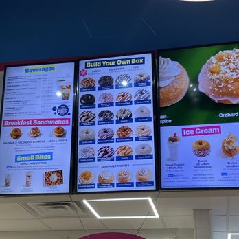 Duck Donuts - Two digital menu screens show various donuts, beverages, breakfast sandwiches, and ice cream options at a donut shop. - Donuts Near Me - Paramus, New Jersey