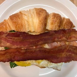 a croissant sandwich with bacon and eggs a croissant sandwich with bacon and eggs