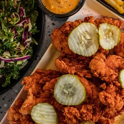 Sexy Sammies 10th - A plate of Nashville hot chicken tenders topped with pickles with slaw on the side