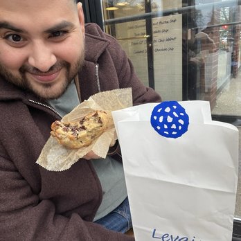 Levain Bakery - Back Bay, Boston - a man, happy as hell, enjoying a chocolate chip cookie - Bakeries Near Me - Boston, Massachusetts